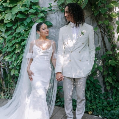 Vanessa Hudgens and her husband, Cole Tucker, looking at each other in their wedding dress.